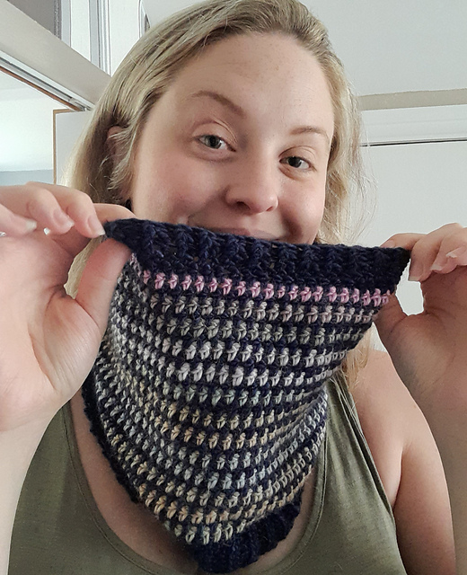 Image shows a woman wearing a handmade crochet cowl. This is an image to show the betwixt crochet cowl pattern. Free crochet accessory patterns