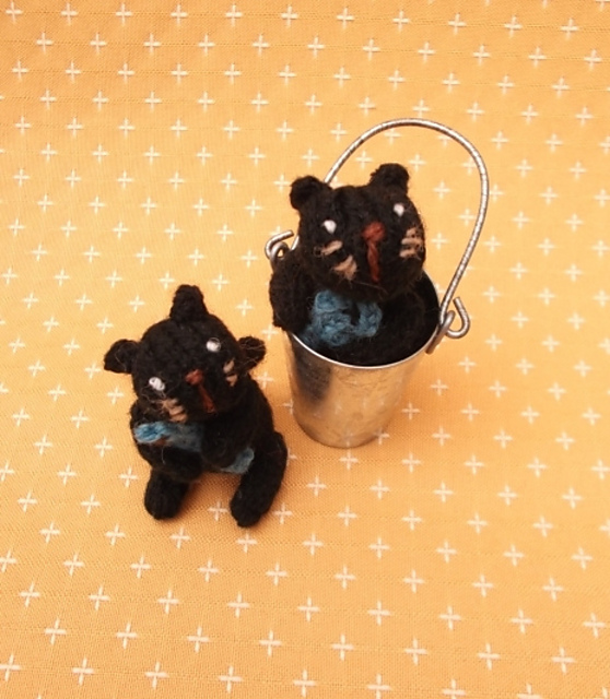 Knitted cat in a tin bucket