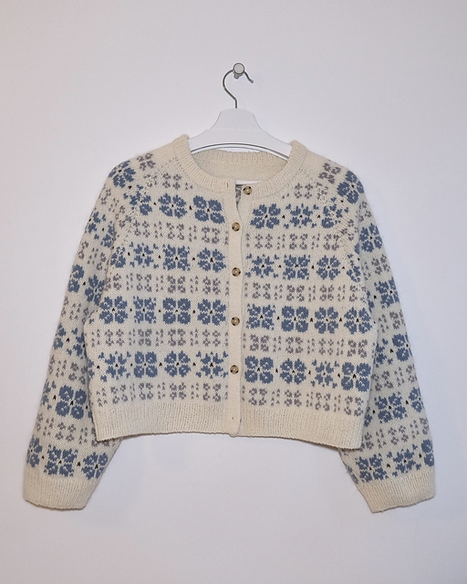 The Camellia Cardigan is started in a top-down flat knitting method to create a neckline, then circular knitting is started while adding steek stitches. The yoke is made by raglan increases, and after separating the body and sleeves, circular knitting is done separately. Cut the center of the front panel through the sticking technique and knit the button band. Finally, pick up stitches from the neckline to make a double-layered neckband.