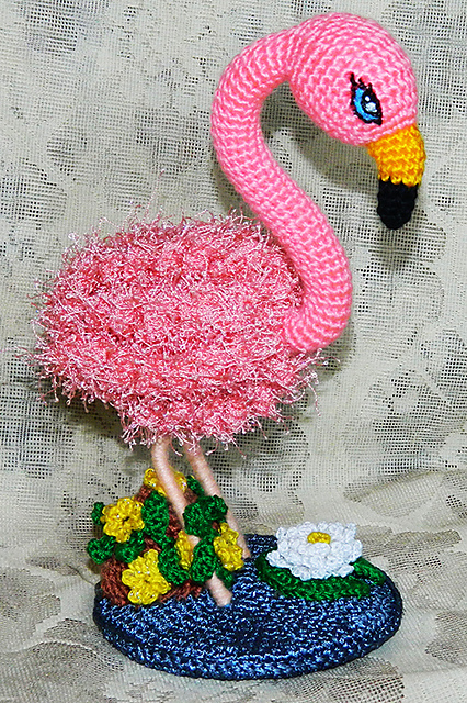 Amigurumi pink flamingo in the pond