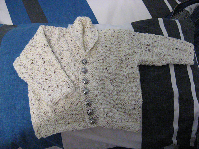 Cardigan with shawl collar, hat and bootees in twisted stitch pattern - Design 9